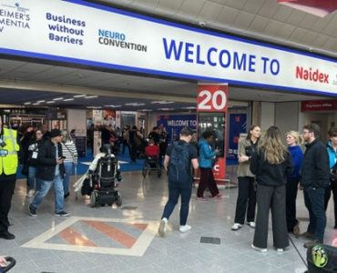 Attendees entering Naidex 2025 at NEC Birmingham, with signage for health and accessibility shows.