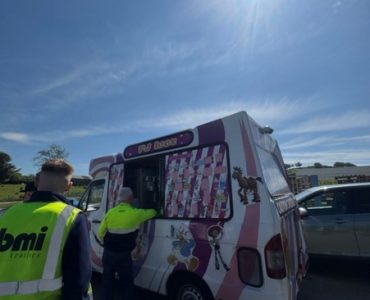 Team members from Meteor Space lined up at the ice cream van on a sunny day.